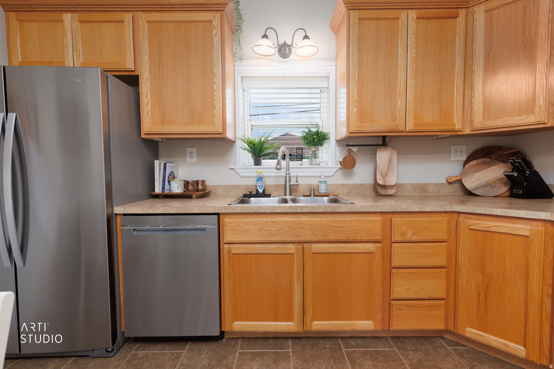 Kitchen featuring wood-finish cabinetry, stainless steel appliances, a double basin sink, and laminate countertops