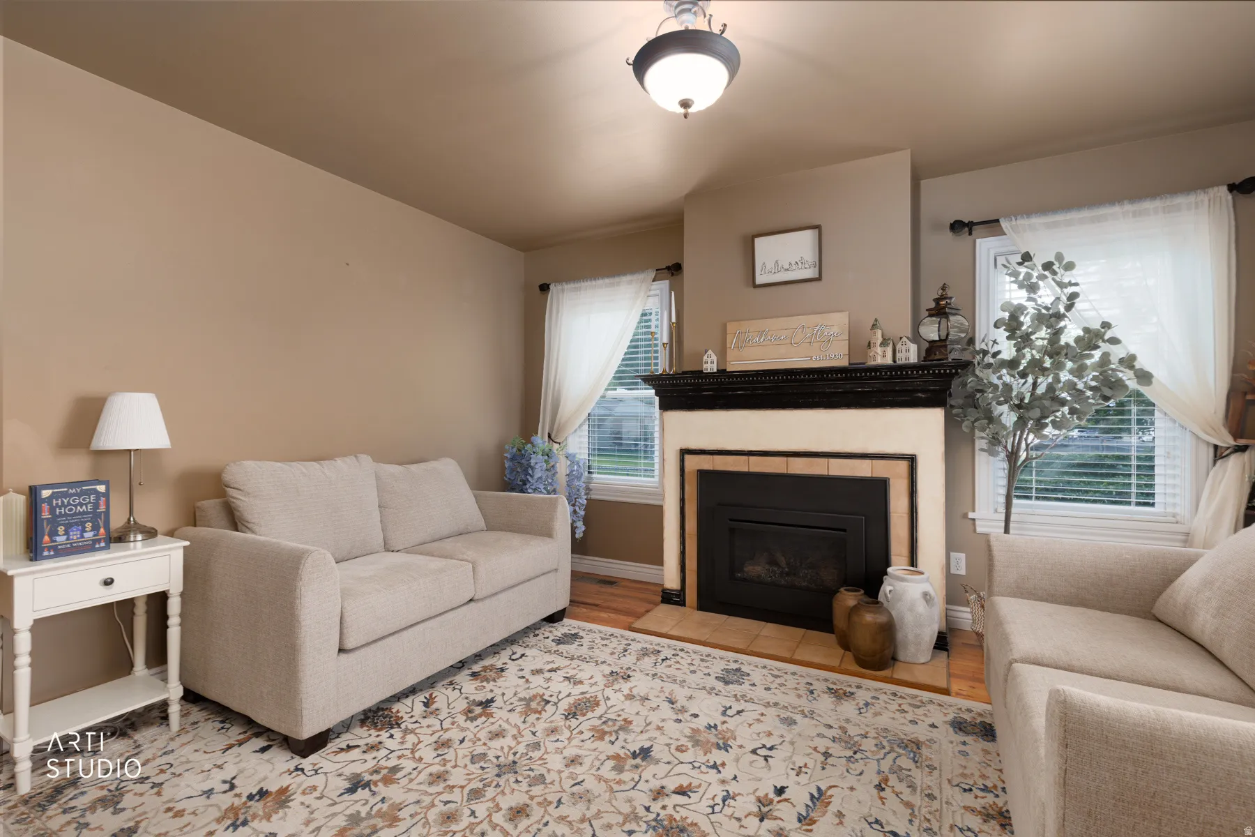 Living area featuring a central fireplace with a dark wood mantelpiece and a tile surround