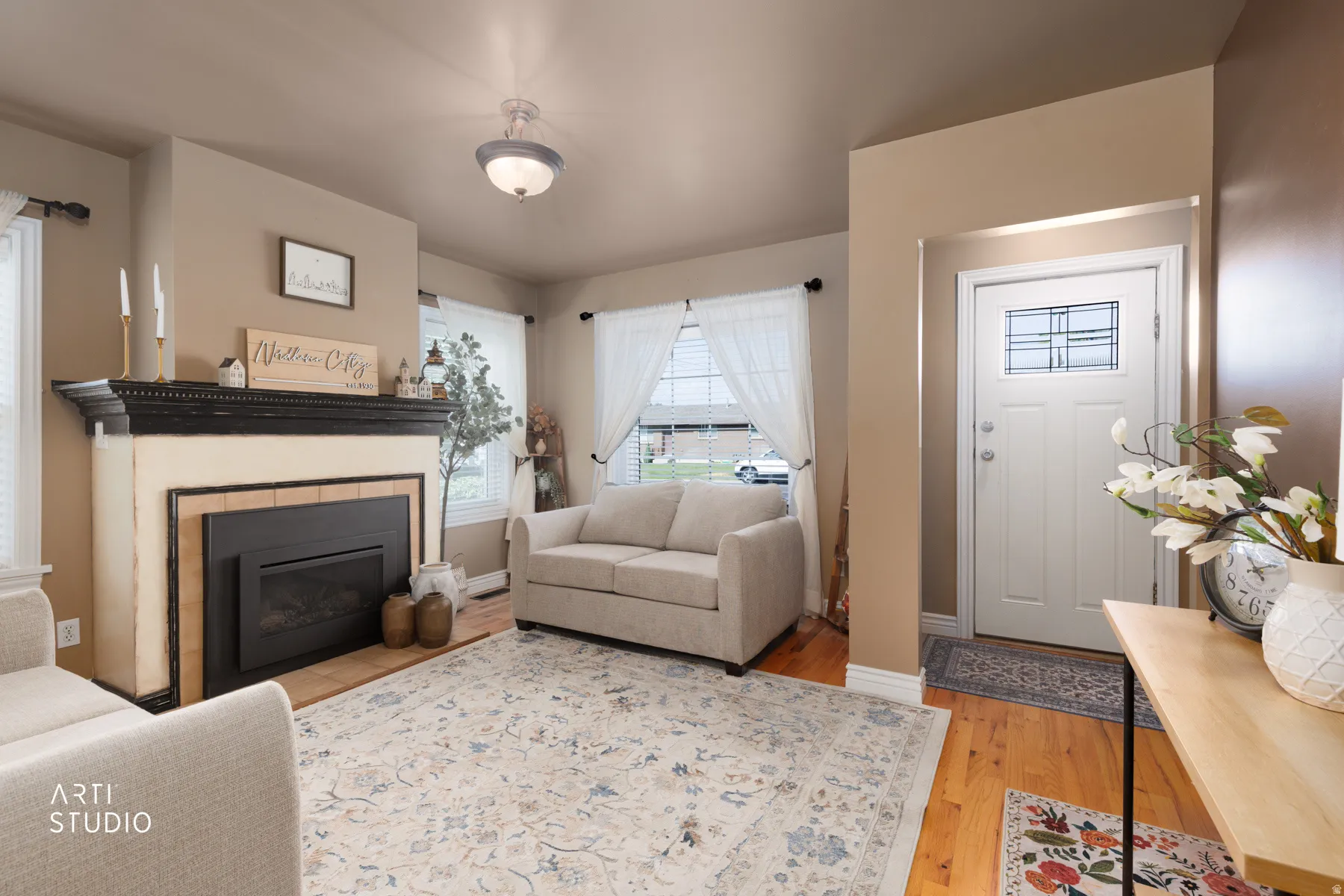 Living space featuring a prominent fireplace with a dark wood mantel and a tiled hearth