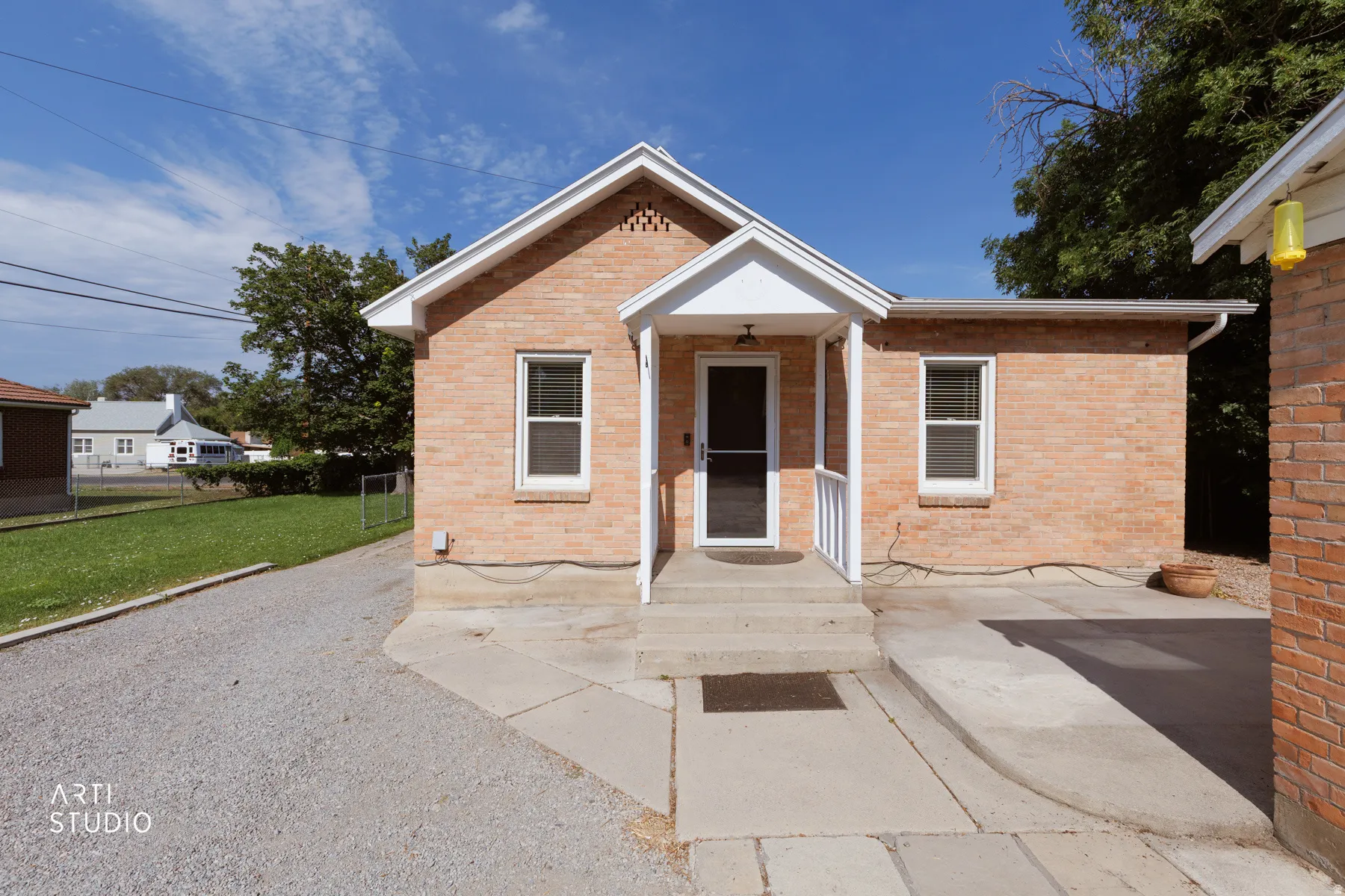 Brick exterior featuring a covered front porch, white window trim, and a concrete pathway