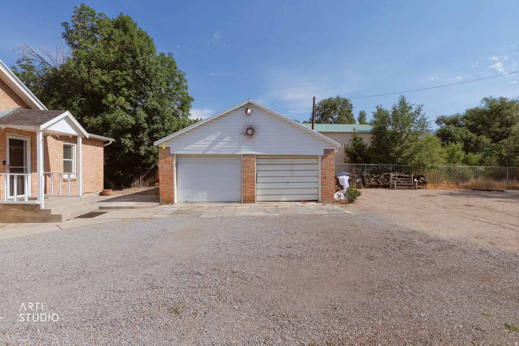 Two-car garage featuring brick facade detailing and white overhead doors