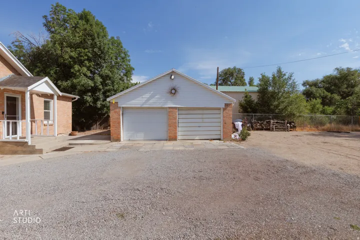 Two-car garage featuring brick facade detailing and white overhead doors