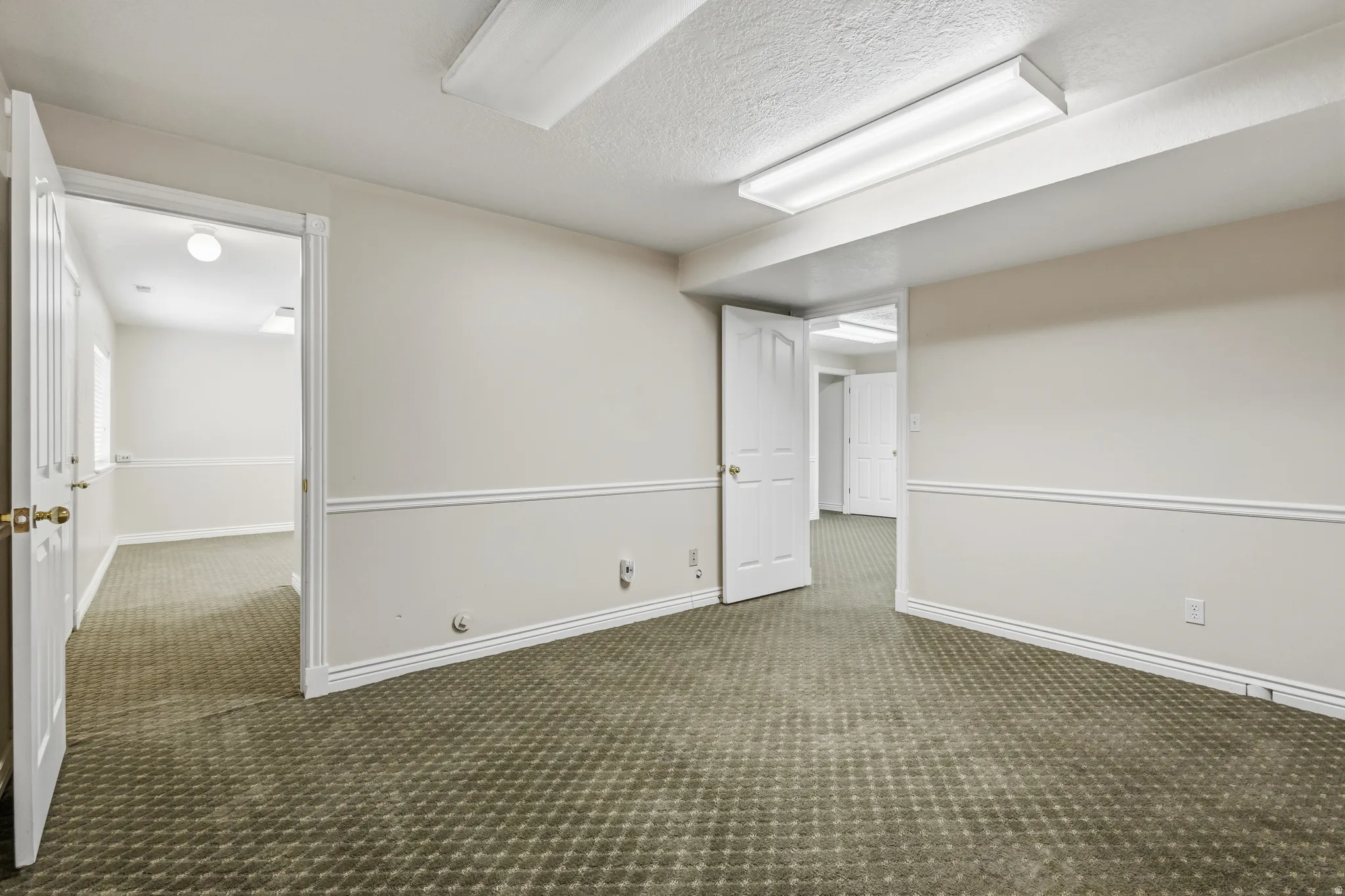 Interior room featuring patterned carpet flooring and neutral wall tones