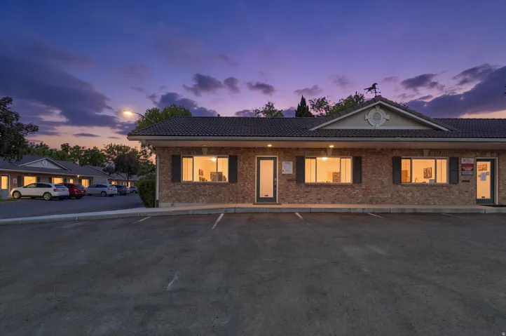 Brick-clad exterior building featuring a tile roof and decorative gable with a round accent