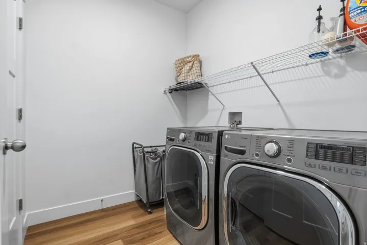 Dedicated laundry area featuring wood-finish flooring