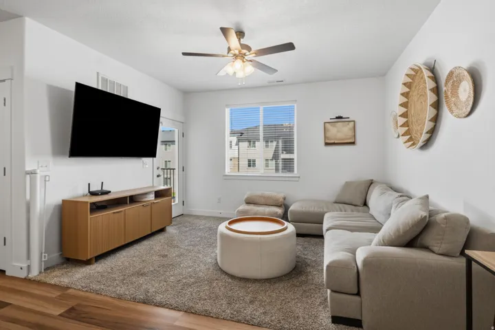 Spacious living area featuring neutral carpeting and wood-finish flooring