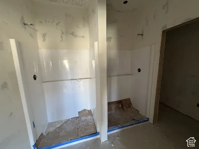 Dual walk-in shower stalls featuring white composite surround panels, integrated shelving, and plumbing fixtures