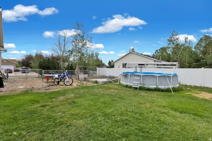 Expansive green lawn with a white privacy fence