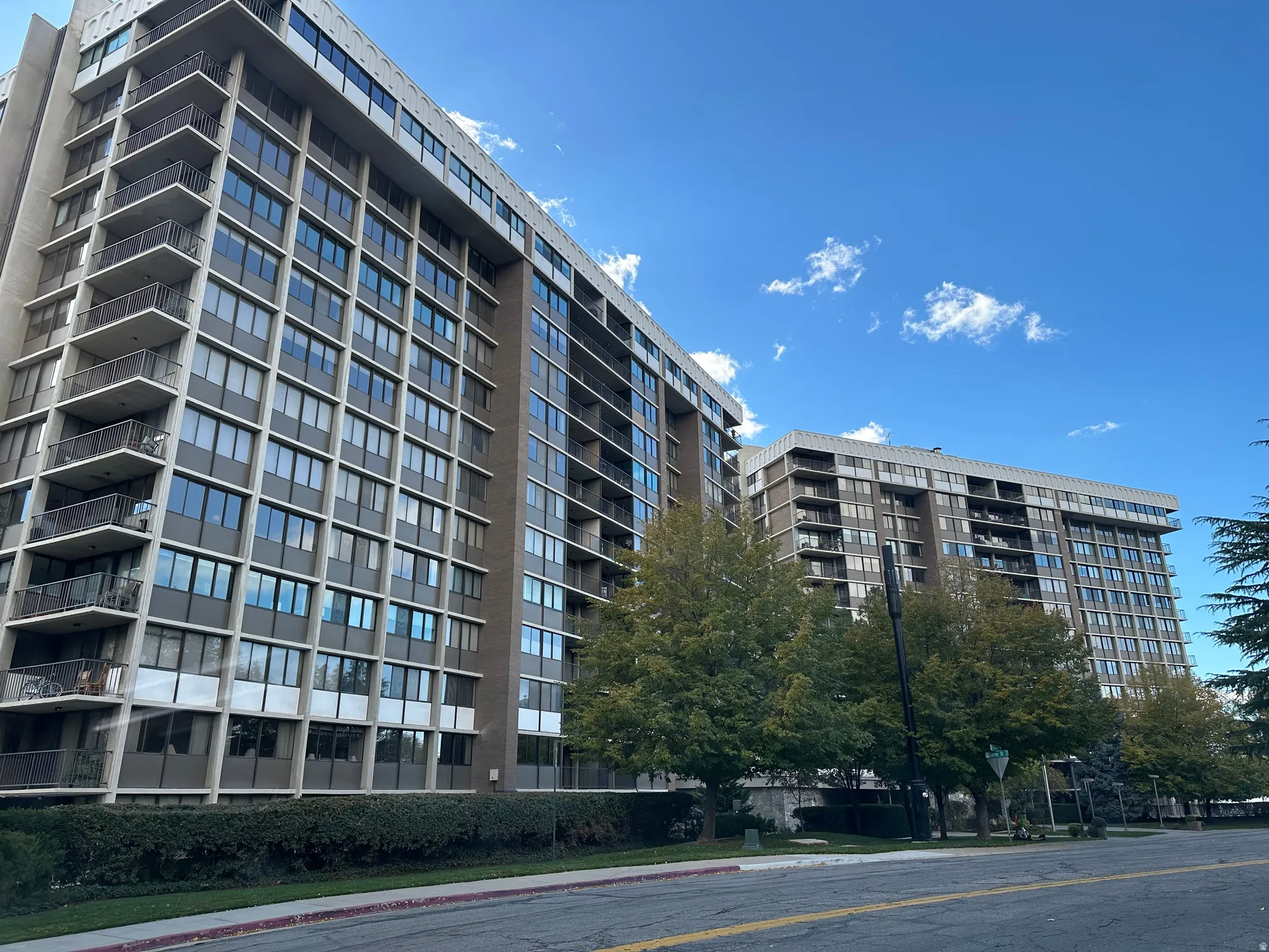 High-rise building with multiple levels, featuring individual balconies with metal railings