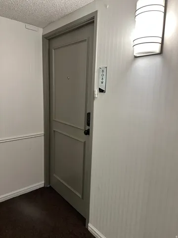 Entry door featuring panel detailing and a digital lock
