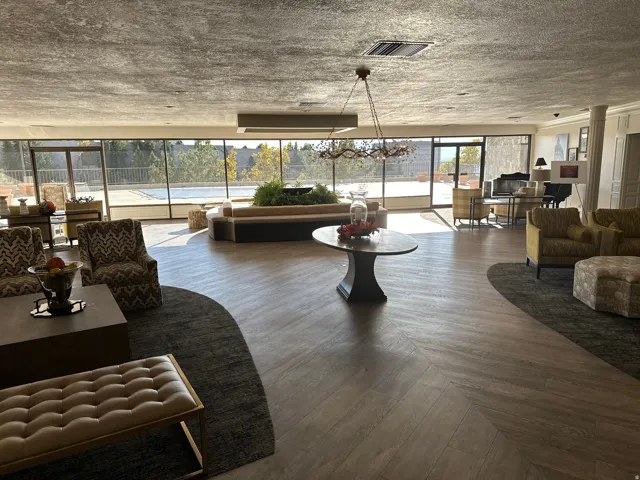 Spacious common area featuring wood-finish flooring, a textured ceiling, and floor-to-ceiling windows