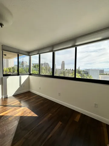 Expansive window wall with roller shades offering city panoramas