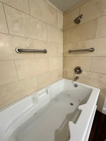 Spa-style jetted bathtub with a tiled surround