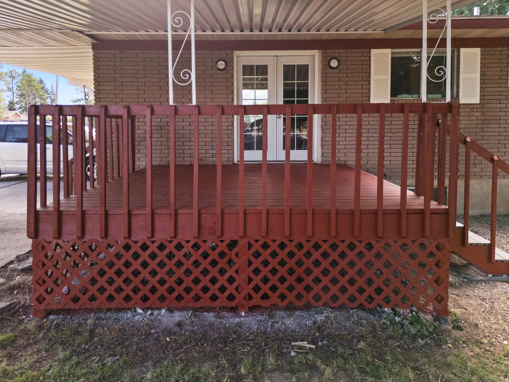 Red-stained wooden deck featuring lattice skirting