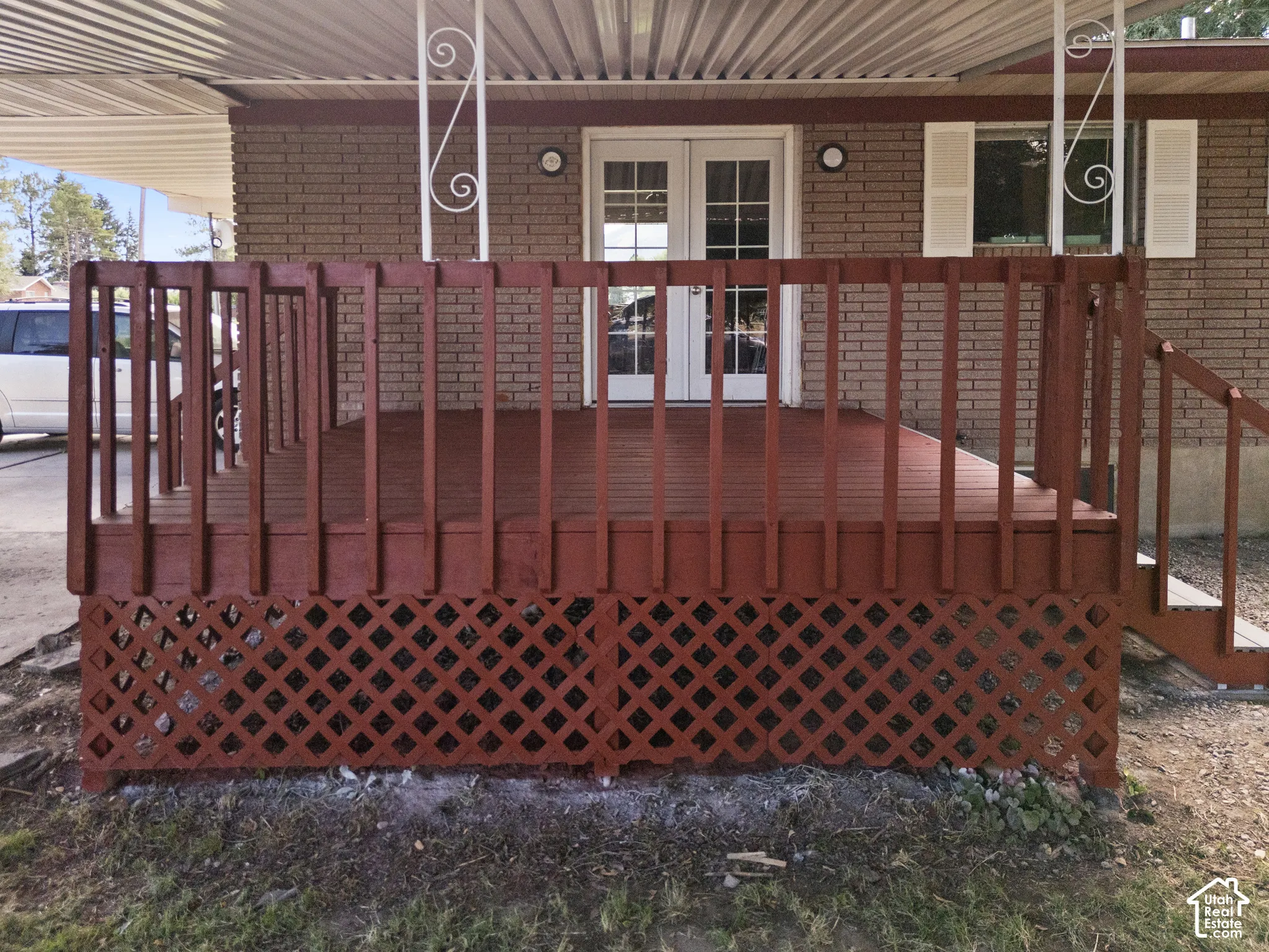 Red-stained wooden deck featuring lattice skirting