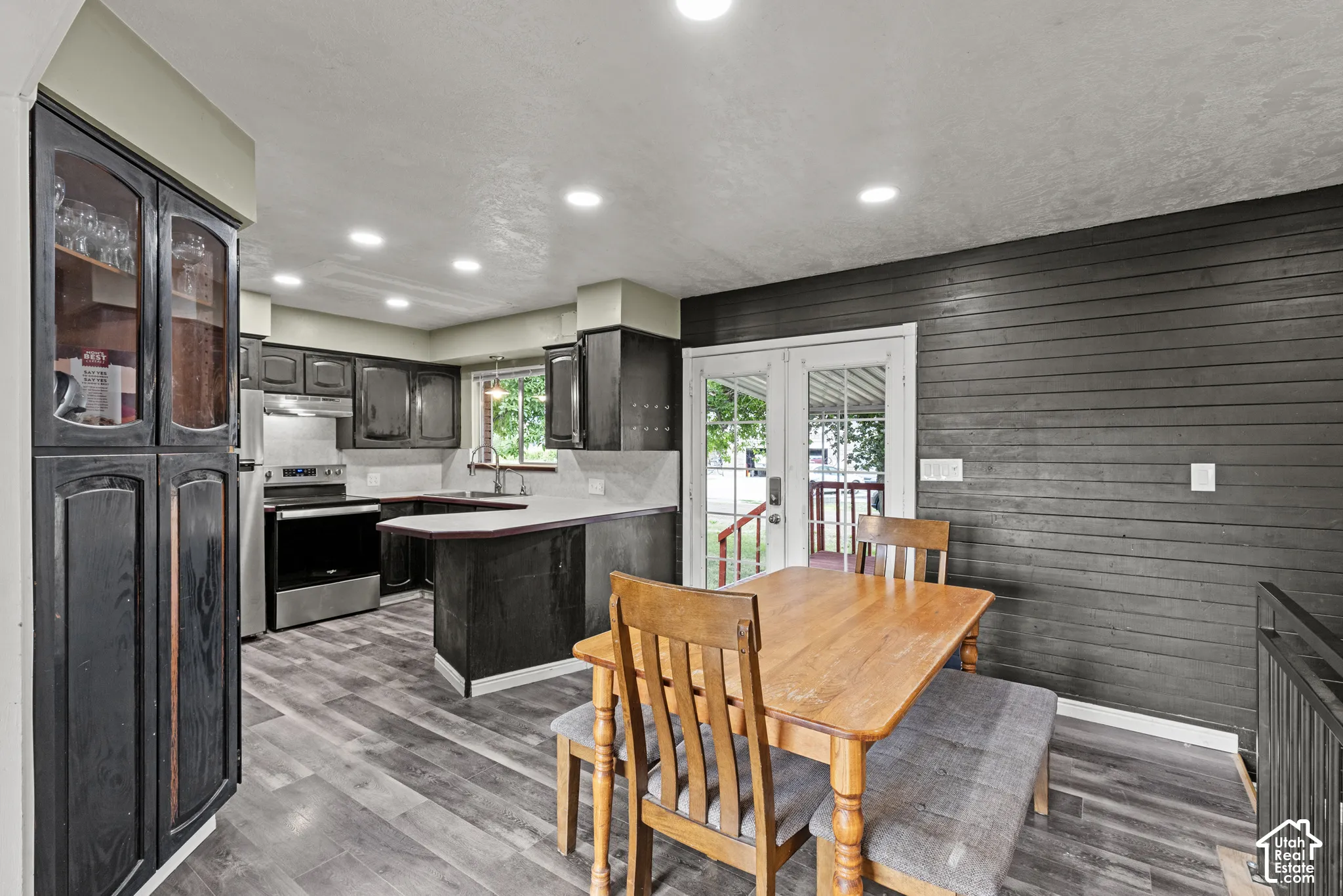 Modern kitchen featuring wood-finish flooring, stainless steel appliances, cabinetry, recessed lighting, and a durable countertop