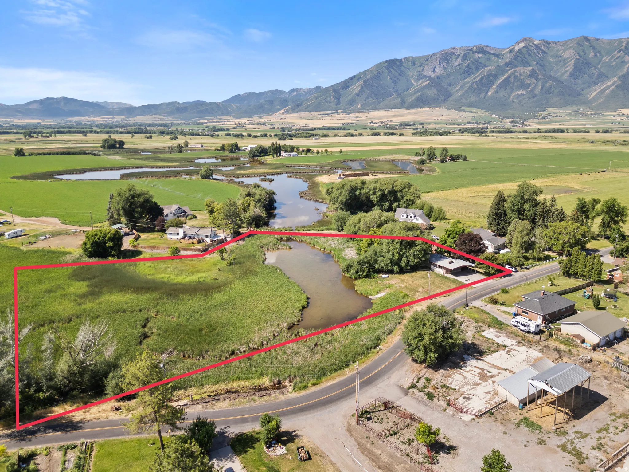 Expansive land parcel featuring natural waterways and a mountainous backdrop