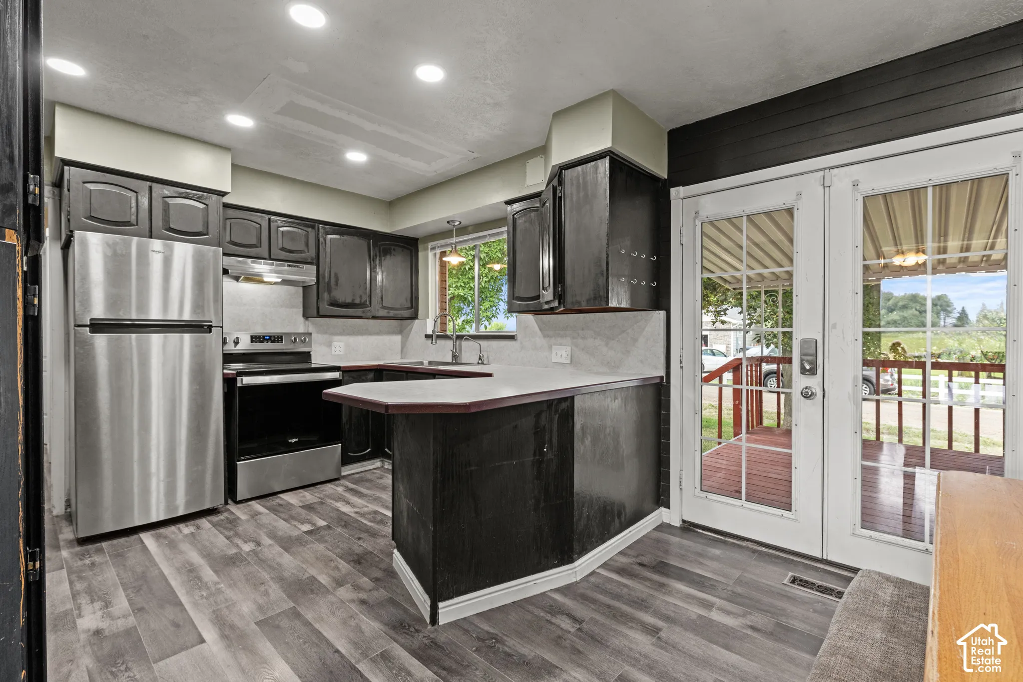 Kitchen featuring stainless steel appliances,  wood cabinetry, and a light-colored countertop