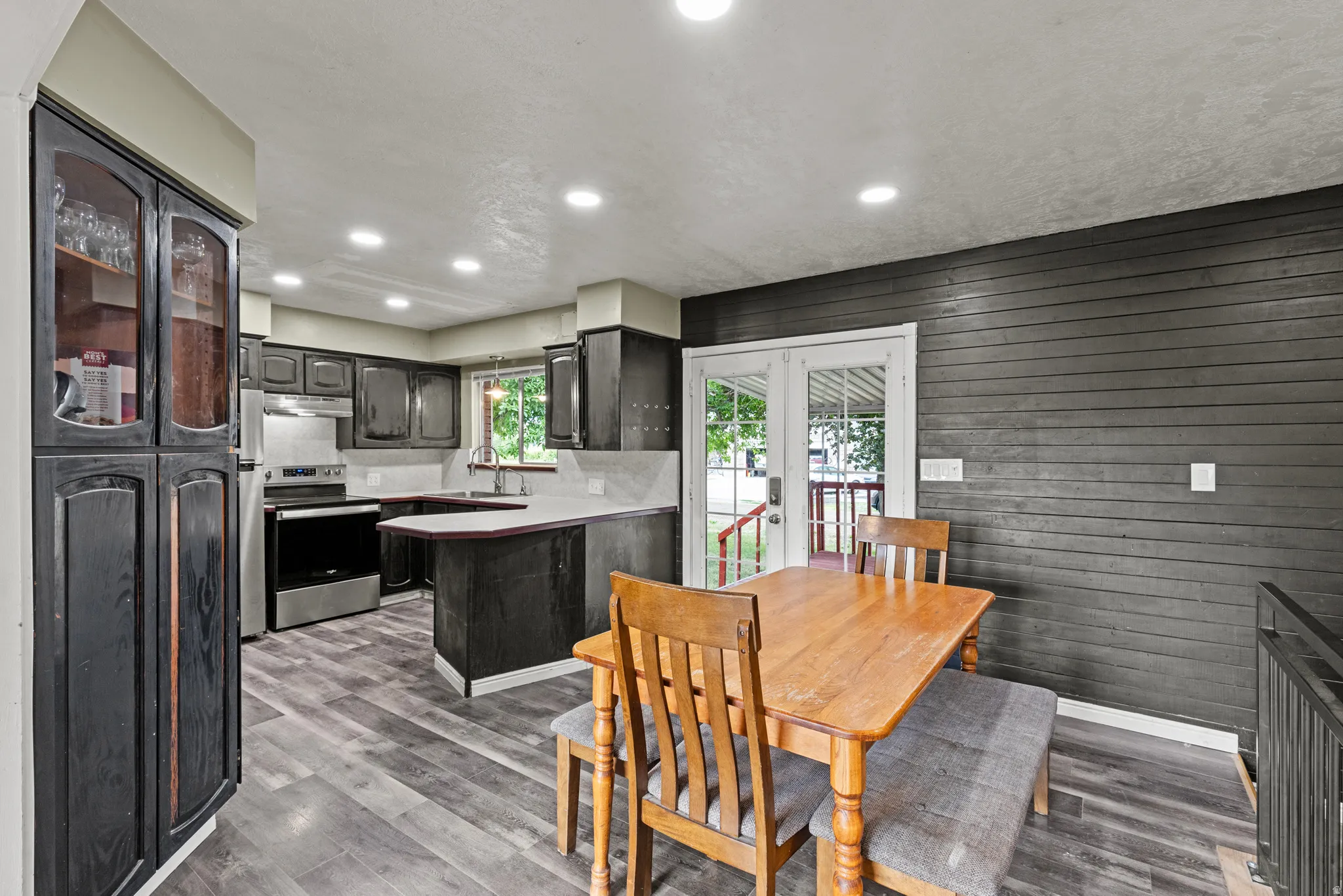 Modern kitchen featuring wood-finish flooring, stainless steel appliances, cabinetry, recessed lighting, and a durable countertop