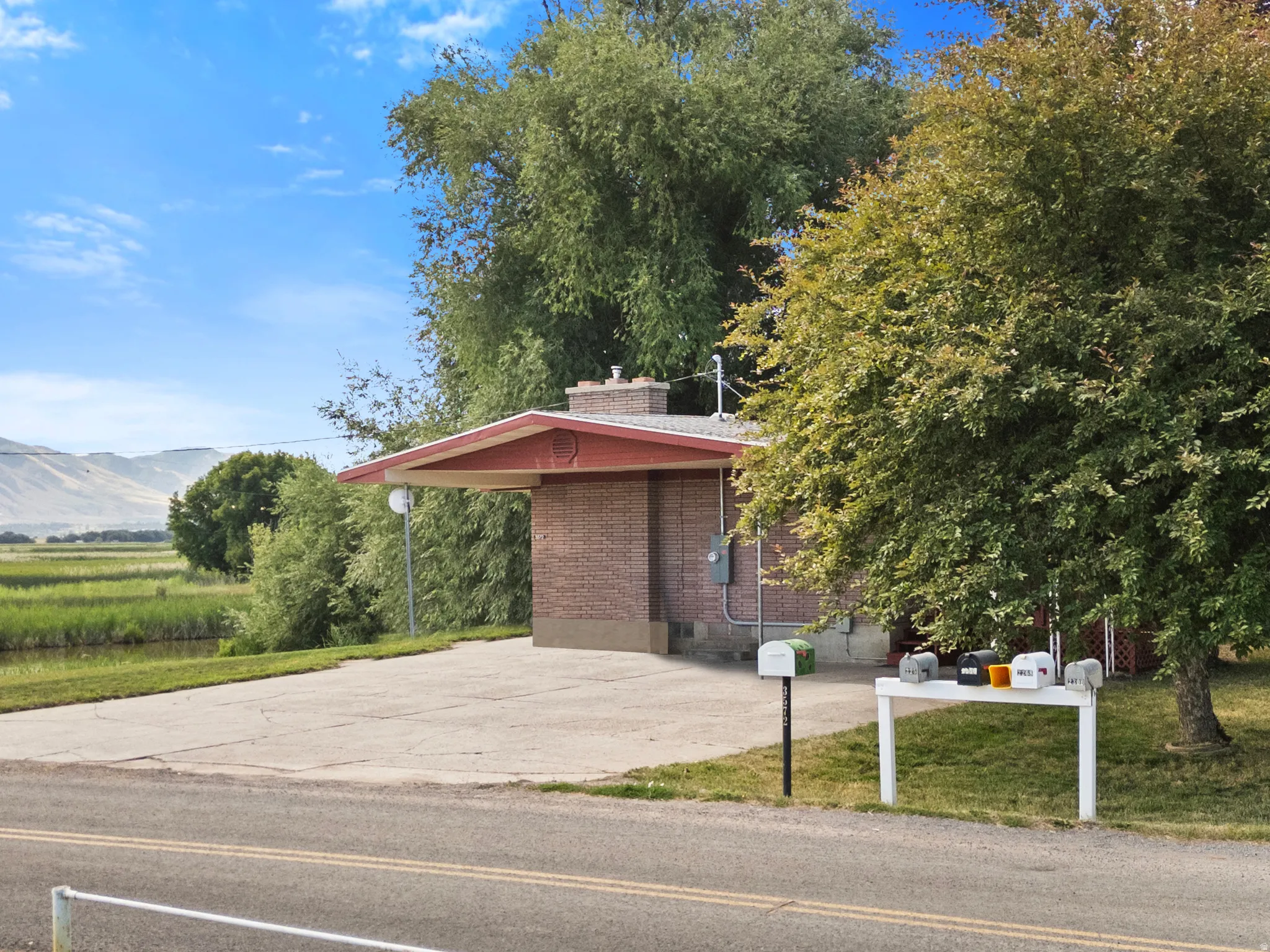 Brick exterior with a carport and mature landscaping