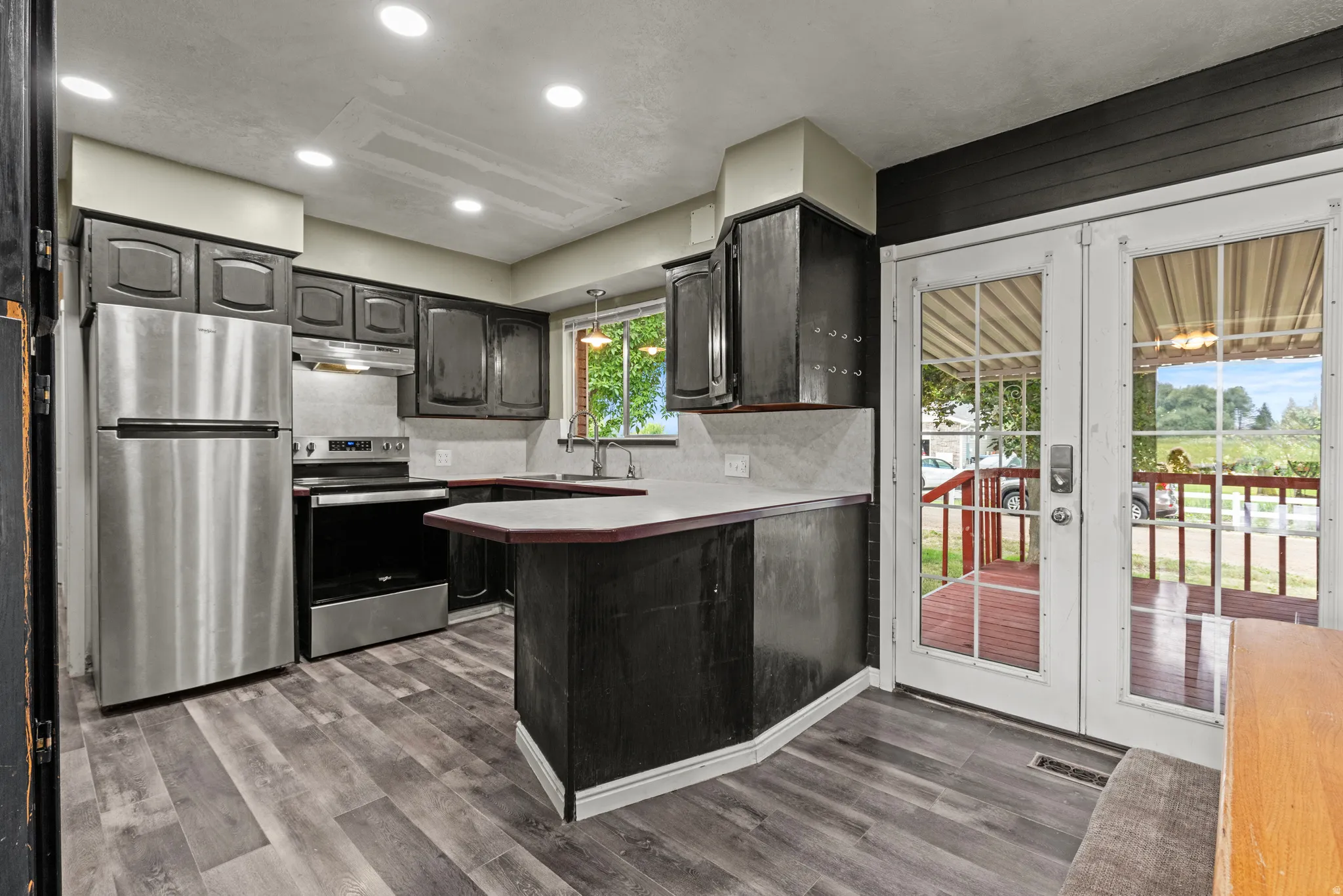 Kitchen featuring stainless steel appliances,  wood cabinetry, and a light-colored countertop
