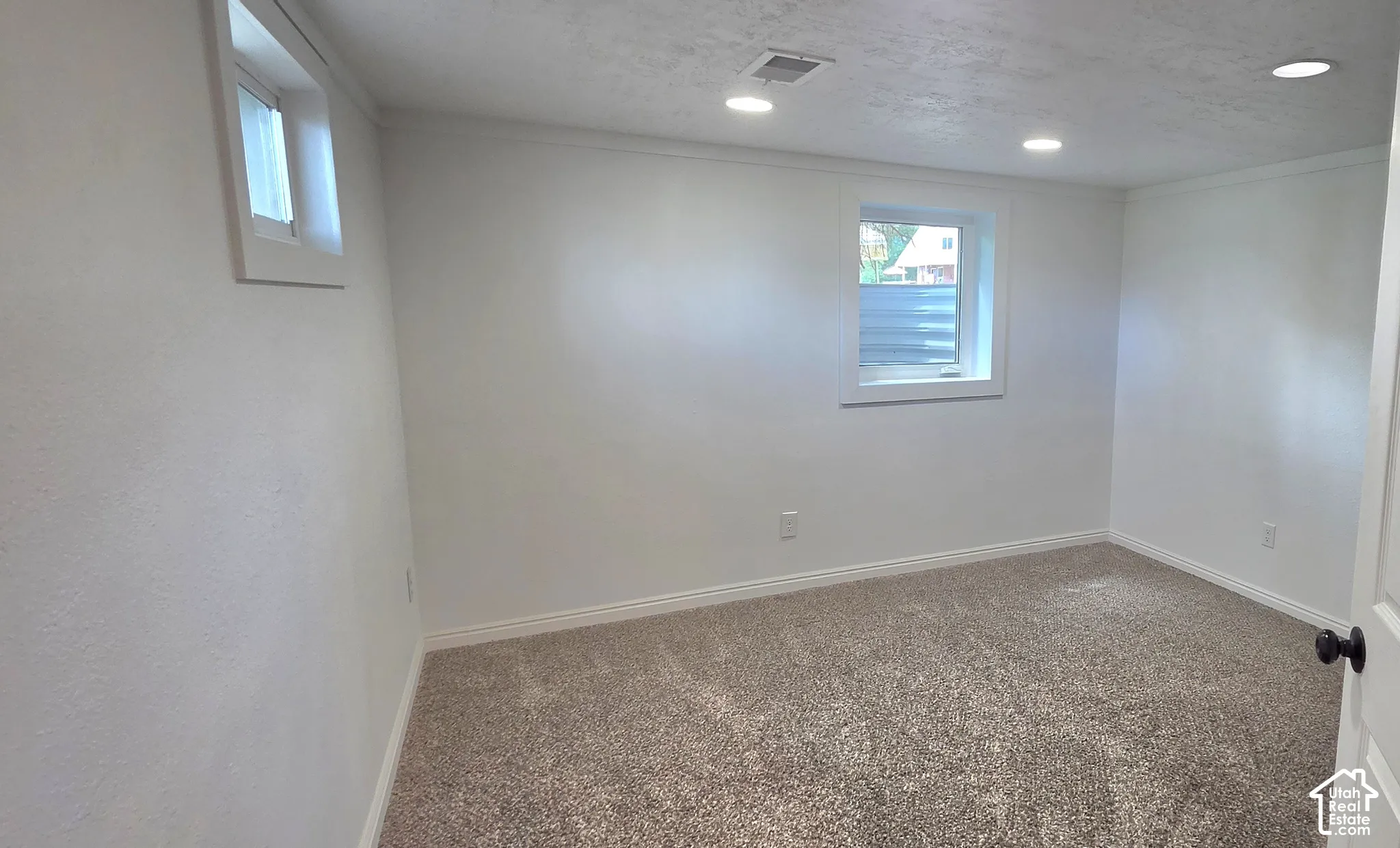 Recessed lighting, white trim, light-colored walls, and neutral carpeting