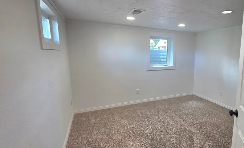 Recessed lighting, white trim, light-colored walls, and neutral carpeting