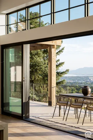 Seamless indoor-outdoor living with floor-to-ceiling sliding glass doors opening onto a composite wood-finish deck
