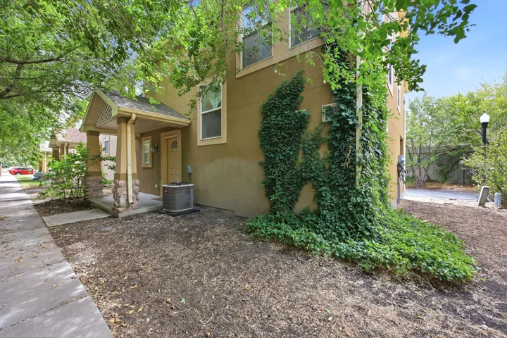 Stucco exterior with a covered porch featuring stone-clad columns and a decorative gable