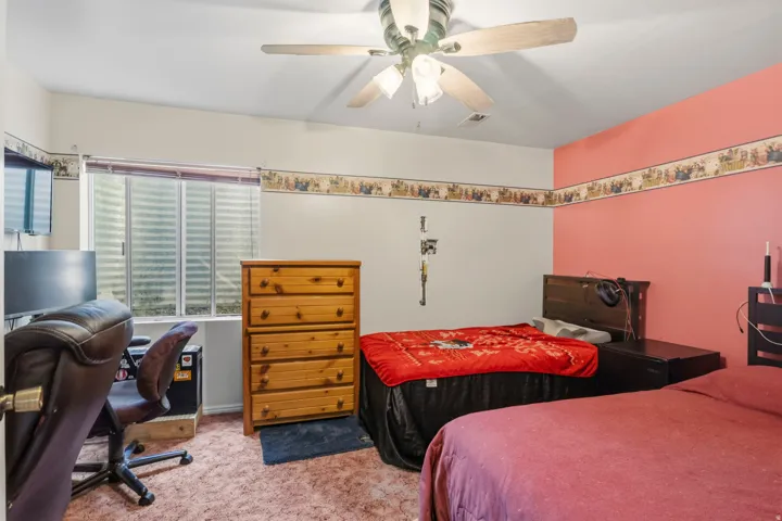 Room with a large window, a ceiling fan with integrated lighting, and two distinct wall colors