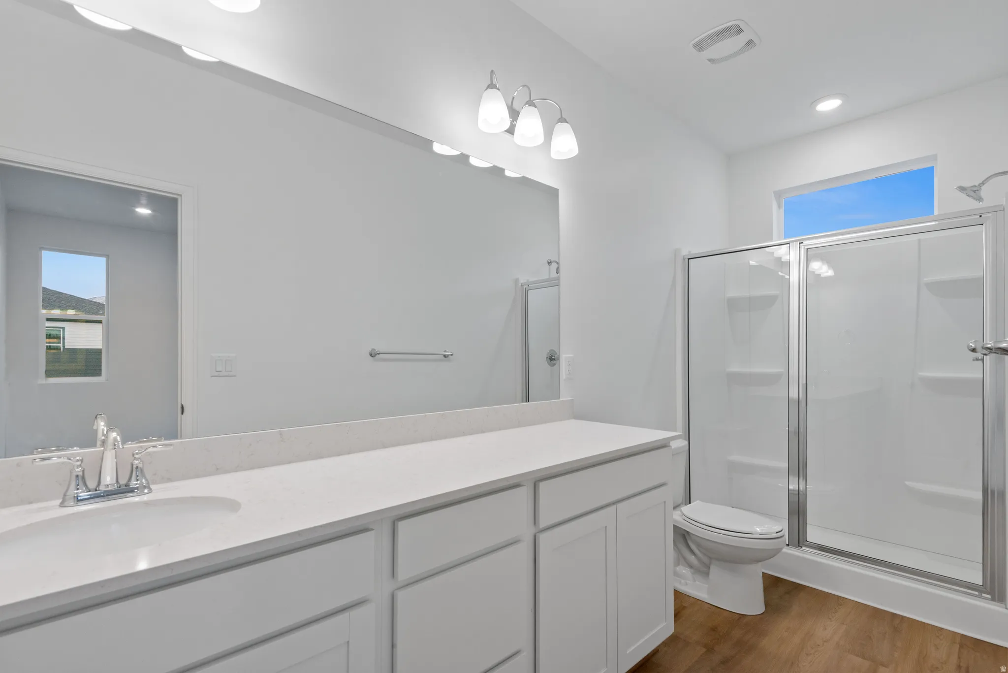 Bathroom featuring a double vanity with stone-finish countertops, undermount sinks, and a large mirror