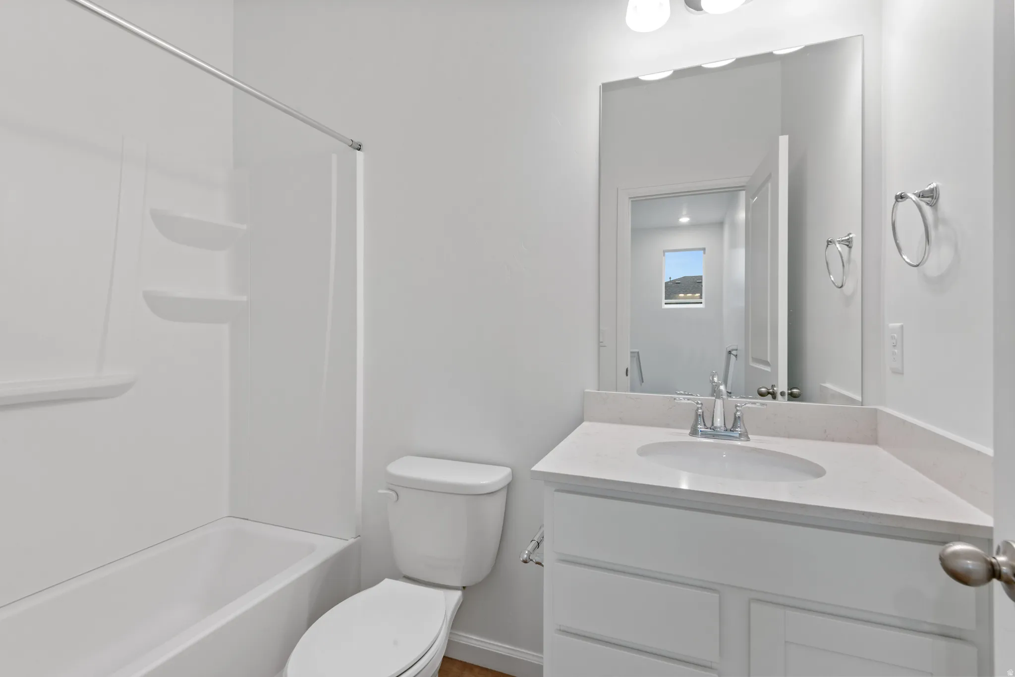 White vanity with integrated sink, stone-finish countertop, and chrome faucet