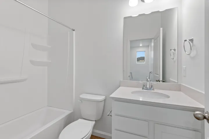 White vanity with integrated sink, stone-finish countertop, and chrome faucet