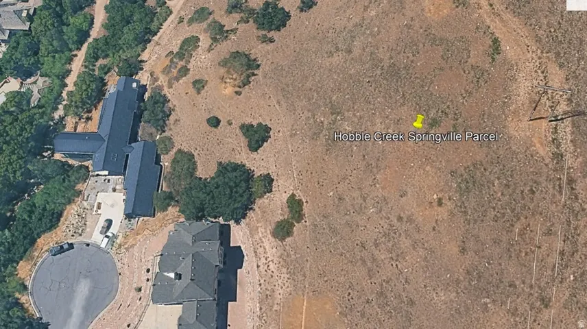 Expansive undeveloped parcel featuring natural terrain and surrounding mature trees