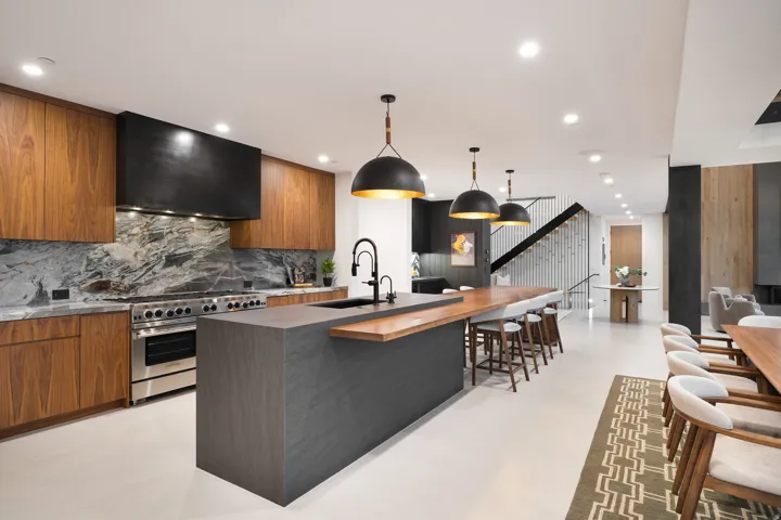 Gourmet kitchen with stainless steel range, wood-finish cabinetry, and a large center island with a wood-finish breakfast bar