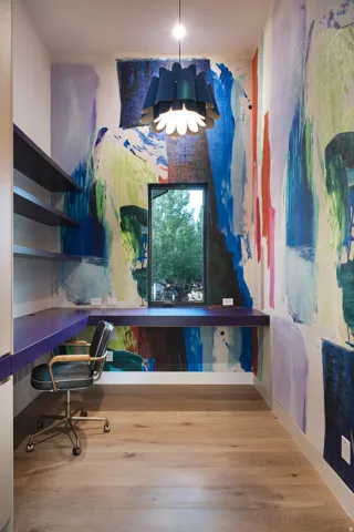 Custom built-in desk, shelving, integrated window, wood-finish flooring, and a decorative pendant light fixture