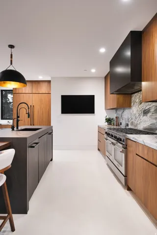 Modern kitchen featuring a central island with a built-in sink and dark cabinetry