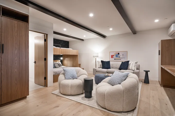Wood-finish flooring, exposed ceiling beams, built-in wooden cabinetry, recessed lighting, and a built-in wooden desk area