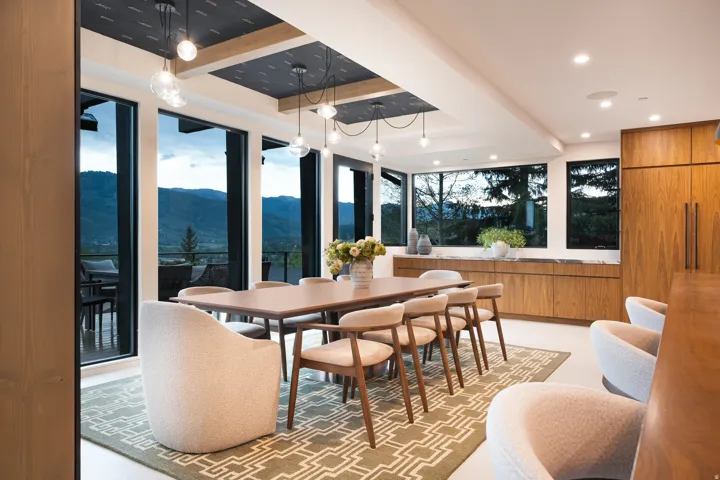 Floor-to-ceiling windows, recessed lighting, wood-finish cabinetry, built-in shelving, and exposed ceiling beams