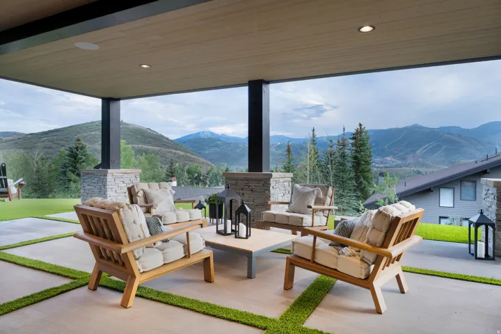 Covered outdoor living space featuring recessed lighting, a wood-finish ceiling, and stone-clad support pillars