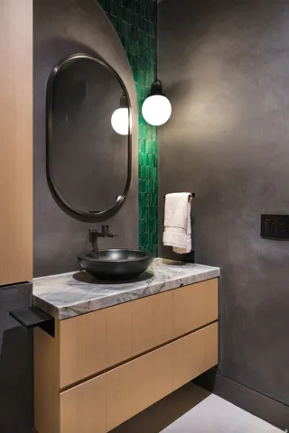 Floating wood-finish vanity with a stone countertop and bowl sink