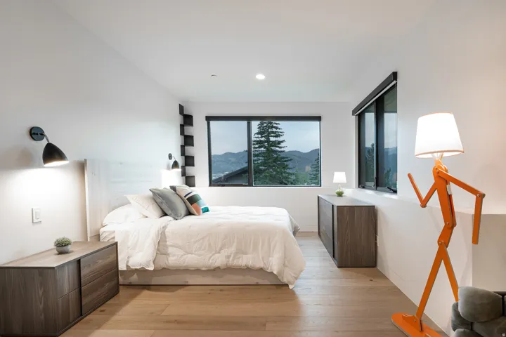 White walls with recessed lighting, light wood-finish flooring, and large windows