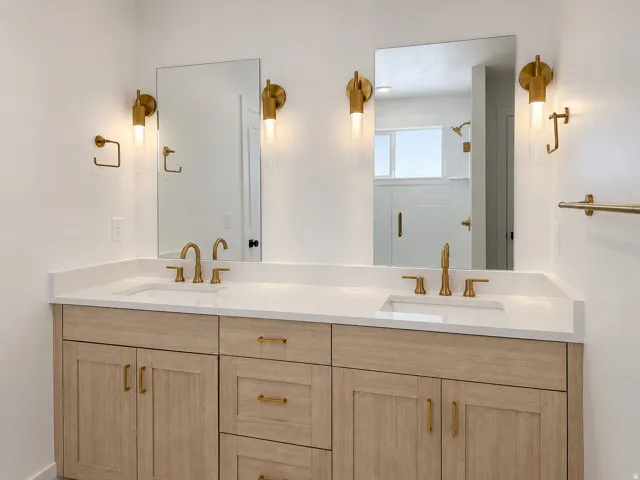 Double vanity with light wood-finish cabinetry and white countertops