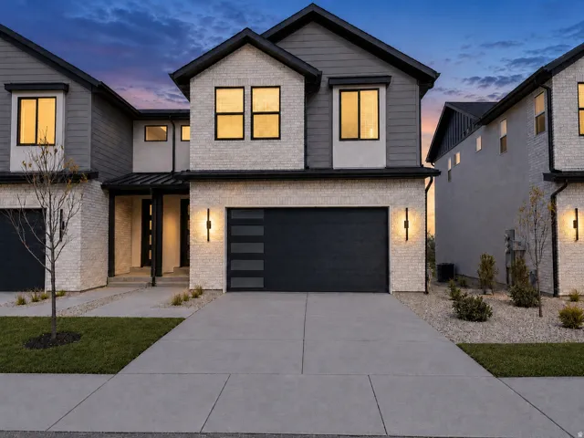 Modern architectural exterior featuring a blend of light brick and dark siding