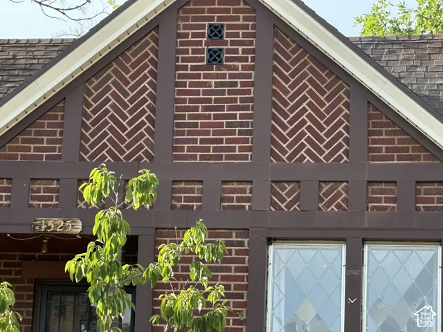 Beautiful artistic brickwork, and  wood trim over the leaded glass front window.