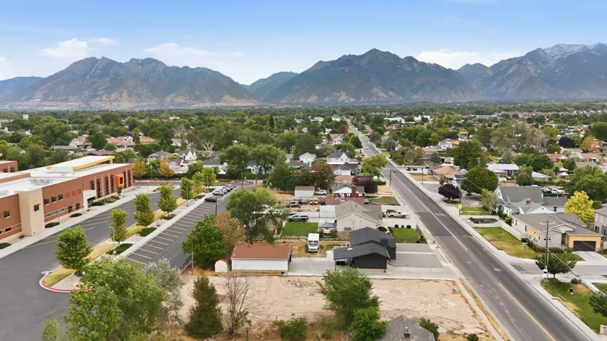 Residential neighborhood with mature trees, established roads, and distant mountain ranges