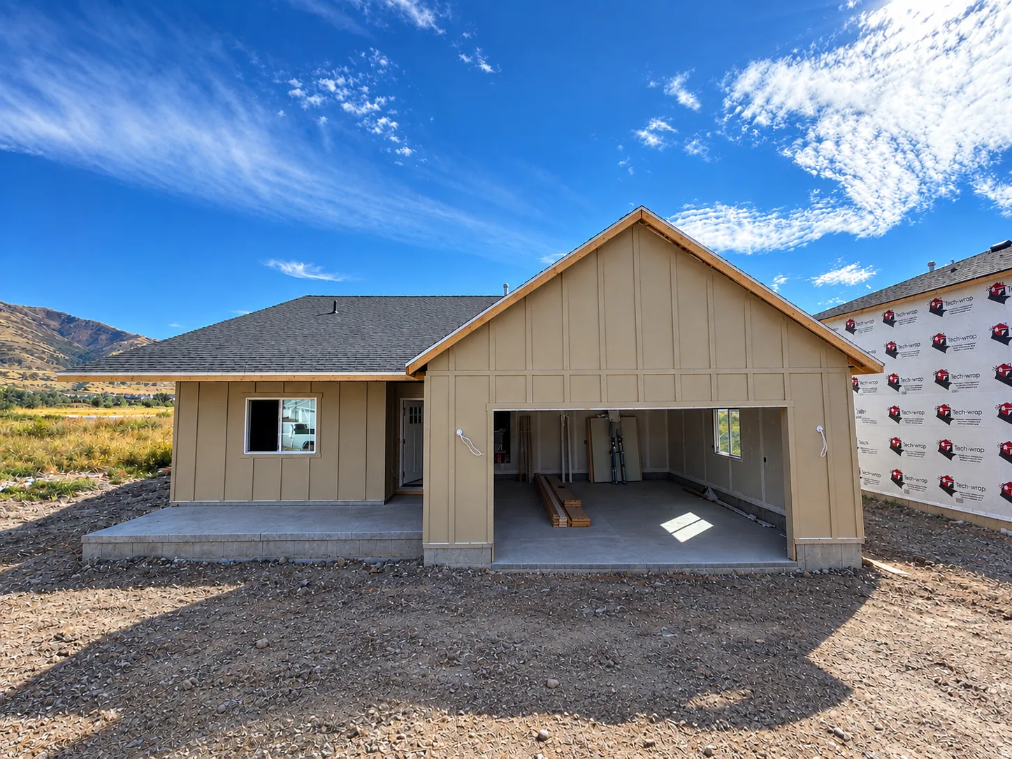 Single-story residence featuring a two-car garage, a concrete patio, and a gabled roofline