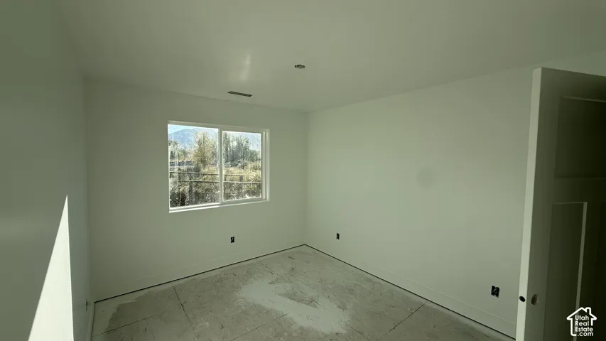 Recessed ceiling lighting, white walls, and a large window