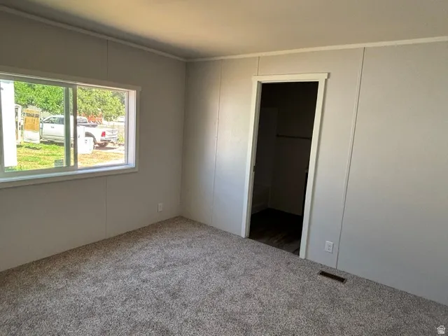 Room featuring neutral carpeting and light-toned wall panels