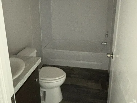 Bathroom featuring a full tub and shower combination, dark wood-finish vanity, and a white basin sink